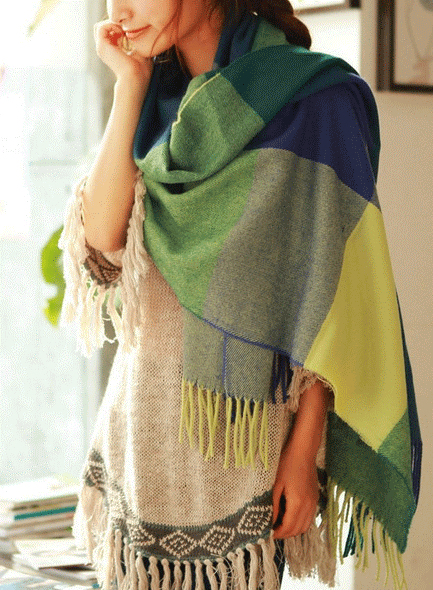 Women's checked fringe scarf worn as a draped shoulder wrap