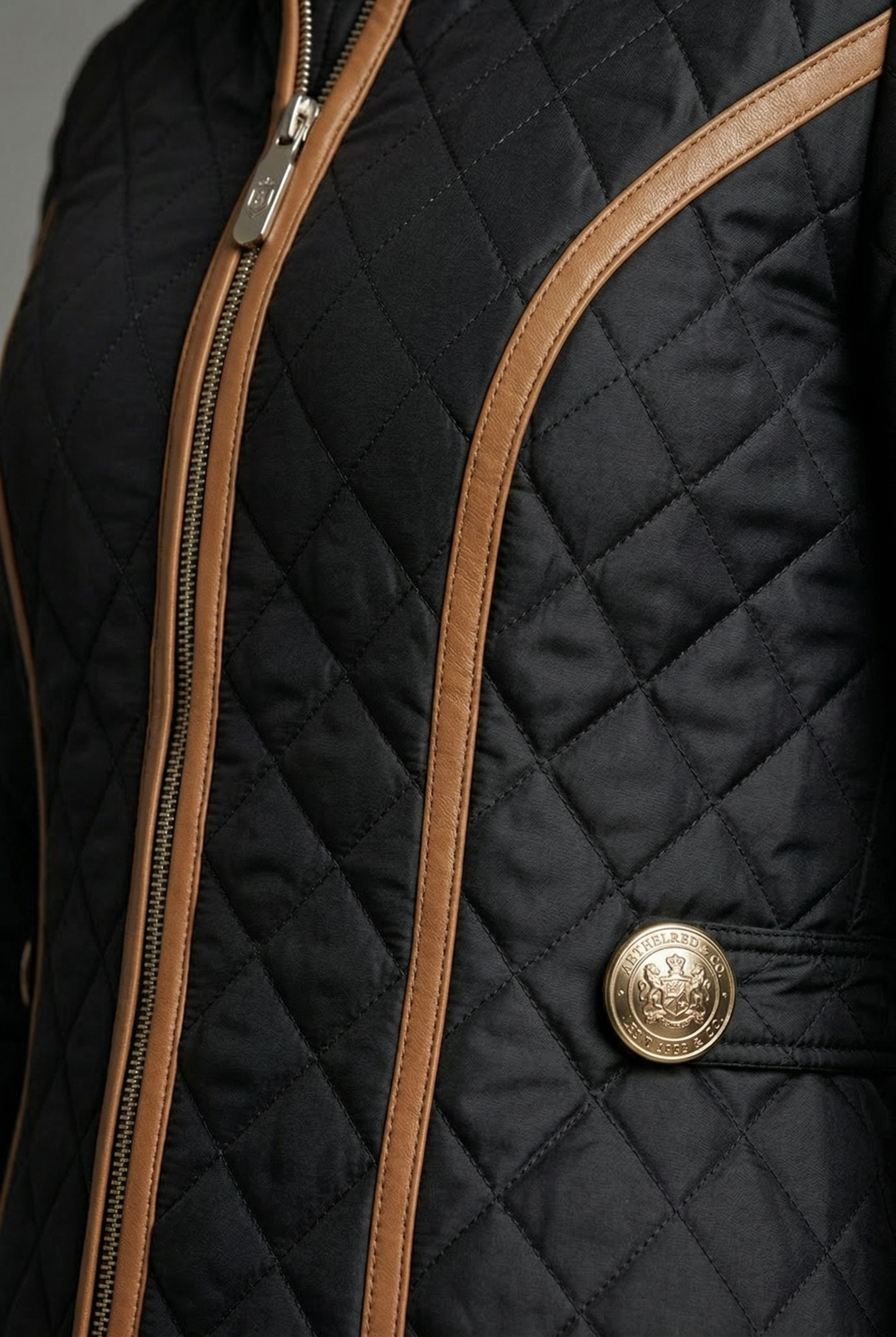 Women's black diamond quilted jacket with tan trim and zip front