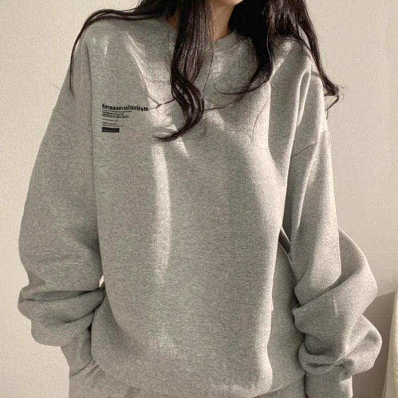 Women's oversized crewneck sweatshirt with long sleeves and a small text graphic
