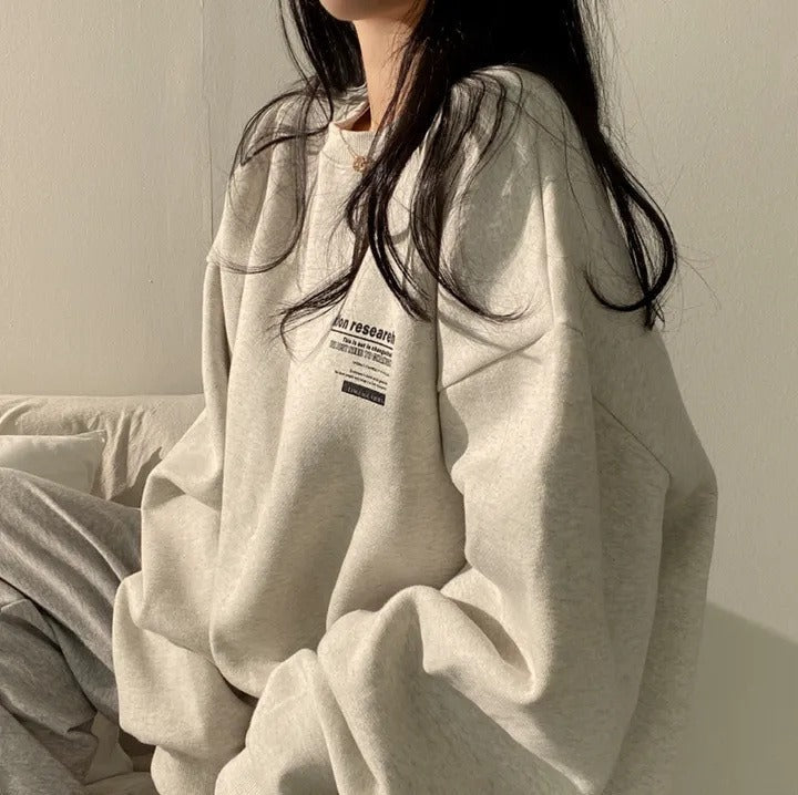 Women's oversized crewneck sweatshirt with long sleeves and a small text graphic