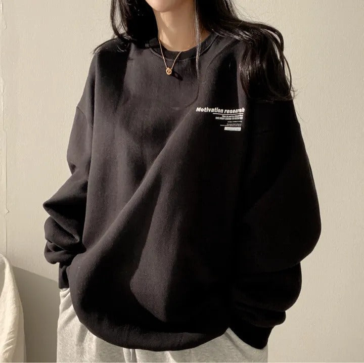 Women's oversized crewneck sweatshirt with long sleeves and a small text graphic