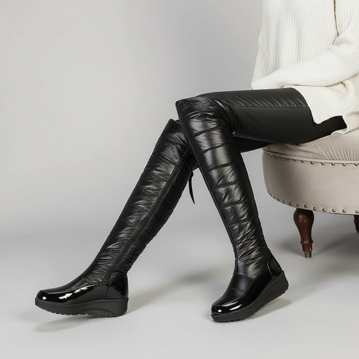 Women's black quilted over-the-knee boots with round toes, flat platform soles and bow detail