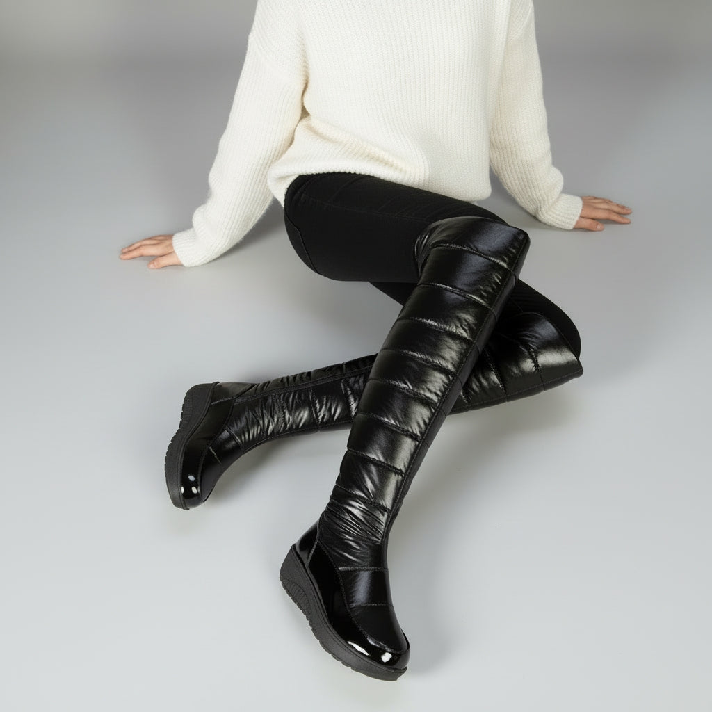 Women's black quilted over-the-knee boots with round toes, flat platform soles and bow detail