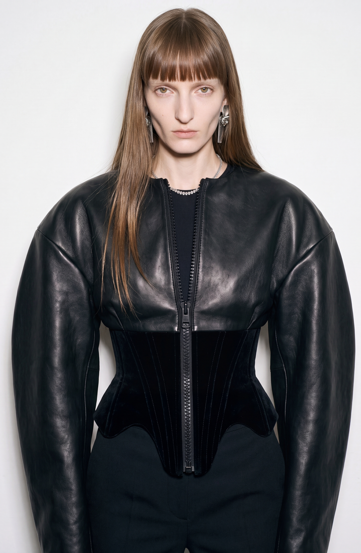 Black women's corset jacket with glossy upper panels, long sleeves and a front zipper