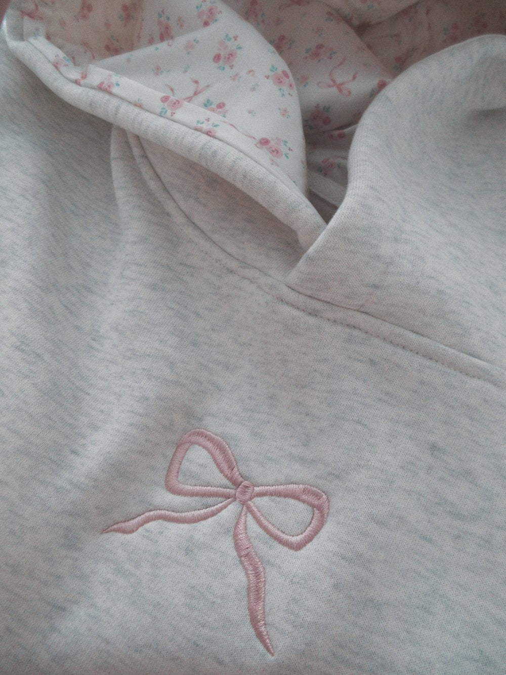 Light grey women's hoodie with floral lined hood and pink embroidery