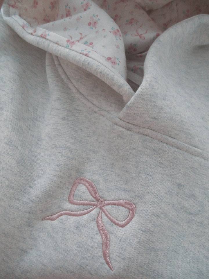 Light grey women's hoodie with floral lined hood and pink embroidery