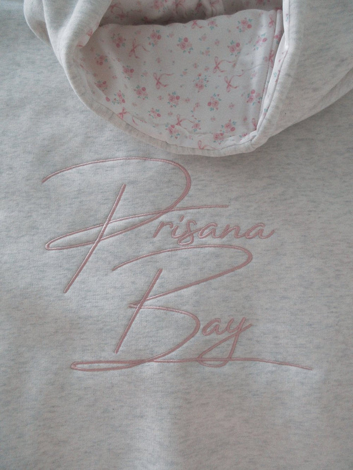 Light grey women's hoodie with floral lined hood and pink embroidery