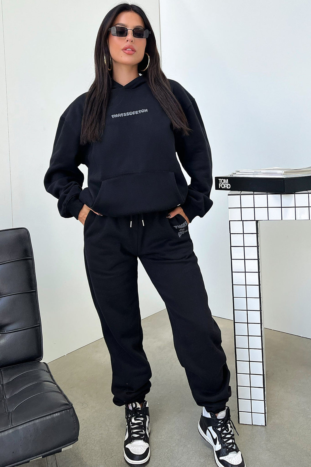 Women's black hooded sweatshirt with contrasting text graphic on the back