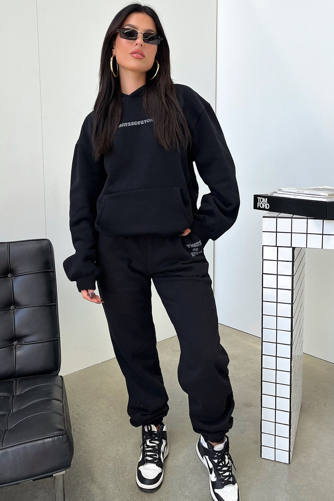 Women's black hooded sweatshirt with contrasting text graphic on the back