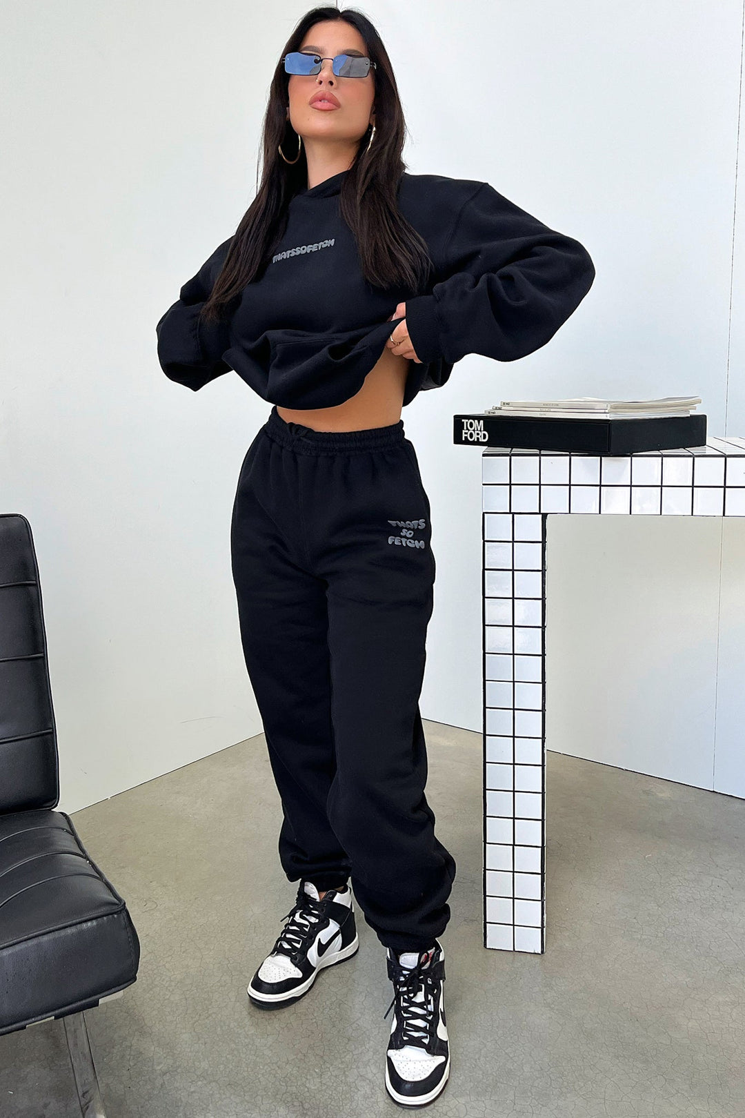 Women's black hooded sweatshirt with contrasting text graphic on the back
