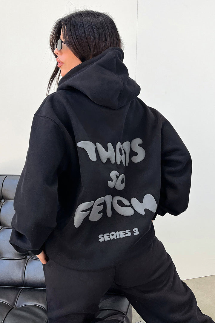 Women's black hooded sweatshirt with contrasting text graphic on the back