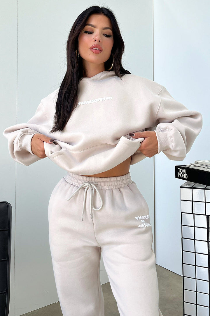 Women's beige cropped hoodie with hood, long sleeves, ribbed trims and chest lettering