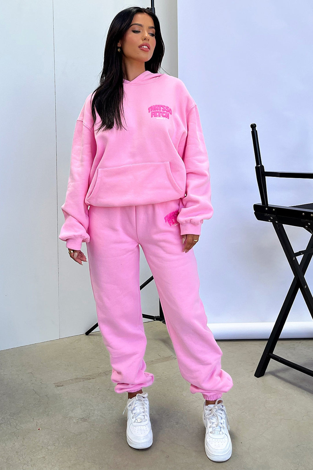 Women's pink cropped hoodie with long sleeves, front pouch pocket and chest graphic