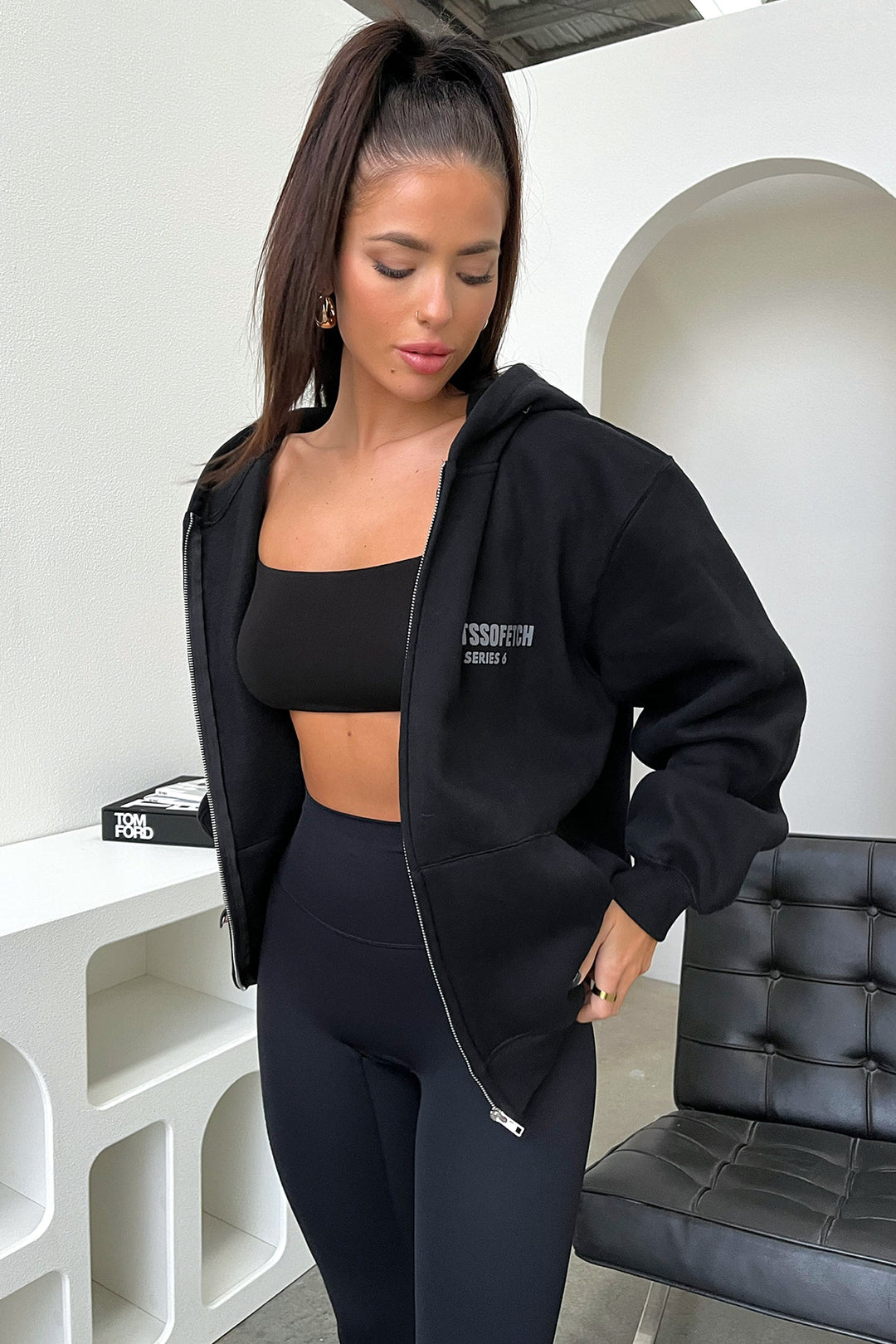 Women's black zip up hoodie with hood, long sleeves and chest text graphic