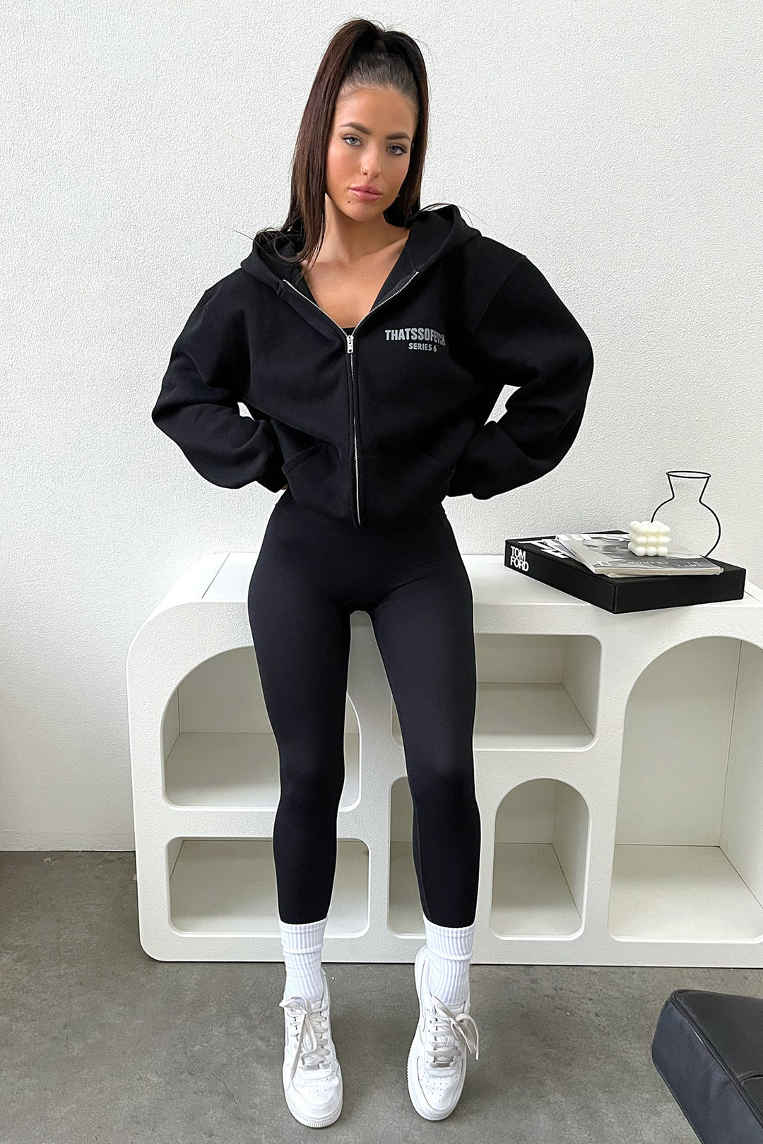 Women's black zip up hoodie with hood, long sleeves and chest text graphic