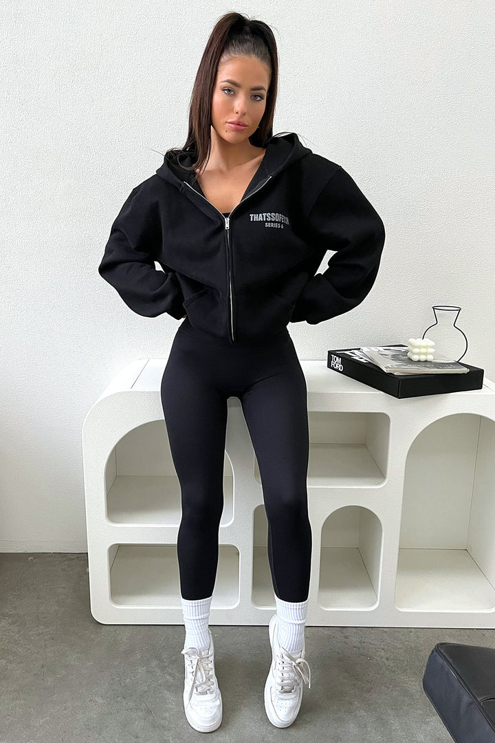 Women's black zip up hoodie with hood, long sleeves and chest text graphic