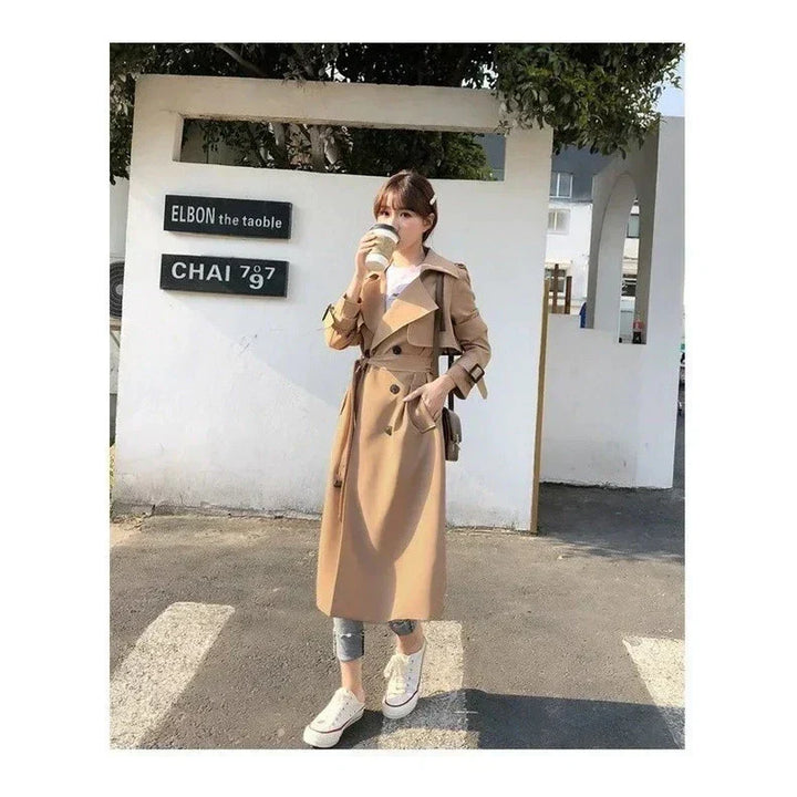 Women's long belted double-breasted trench coat with lapels and cuff straps