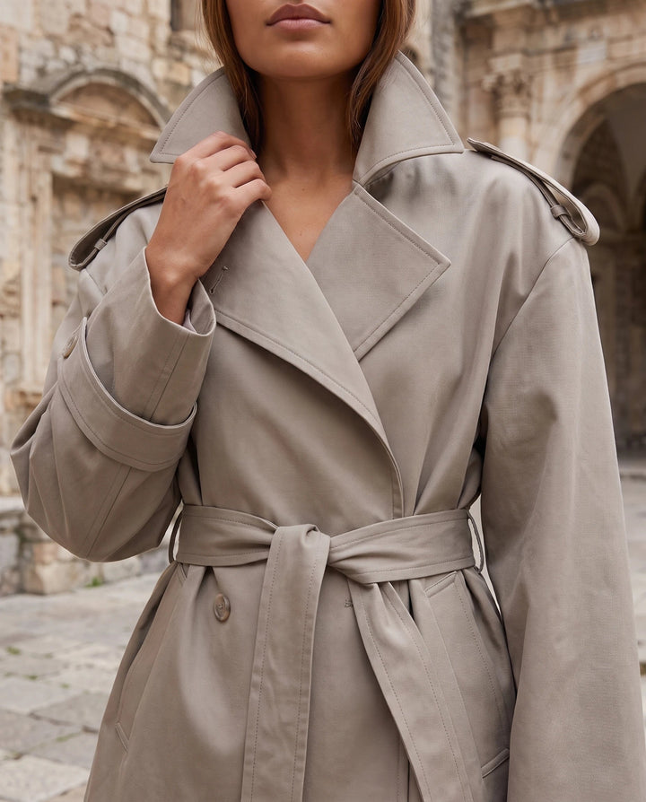 Women's oversized cropped trench jacket with wide lapels, long sleeves and tie belt